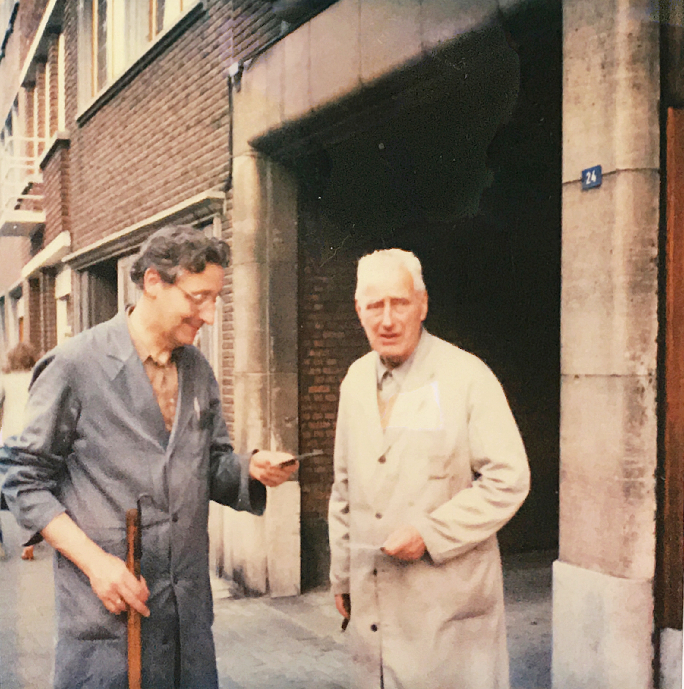 Emiel Mertens en zijn zoon, Raymond, in bedrijfstenue aan de ingang van de koffiebranderij in de Leuvensestraat. Collectie familie Mertens.