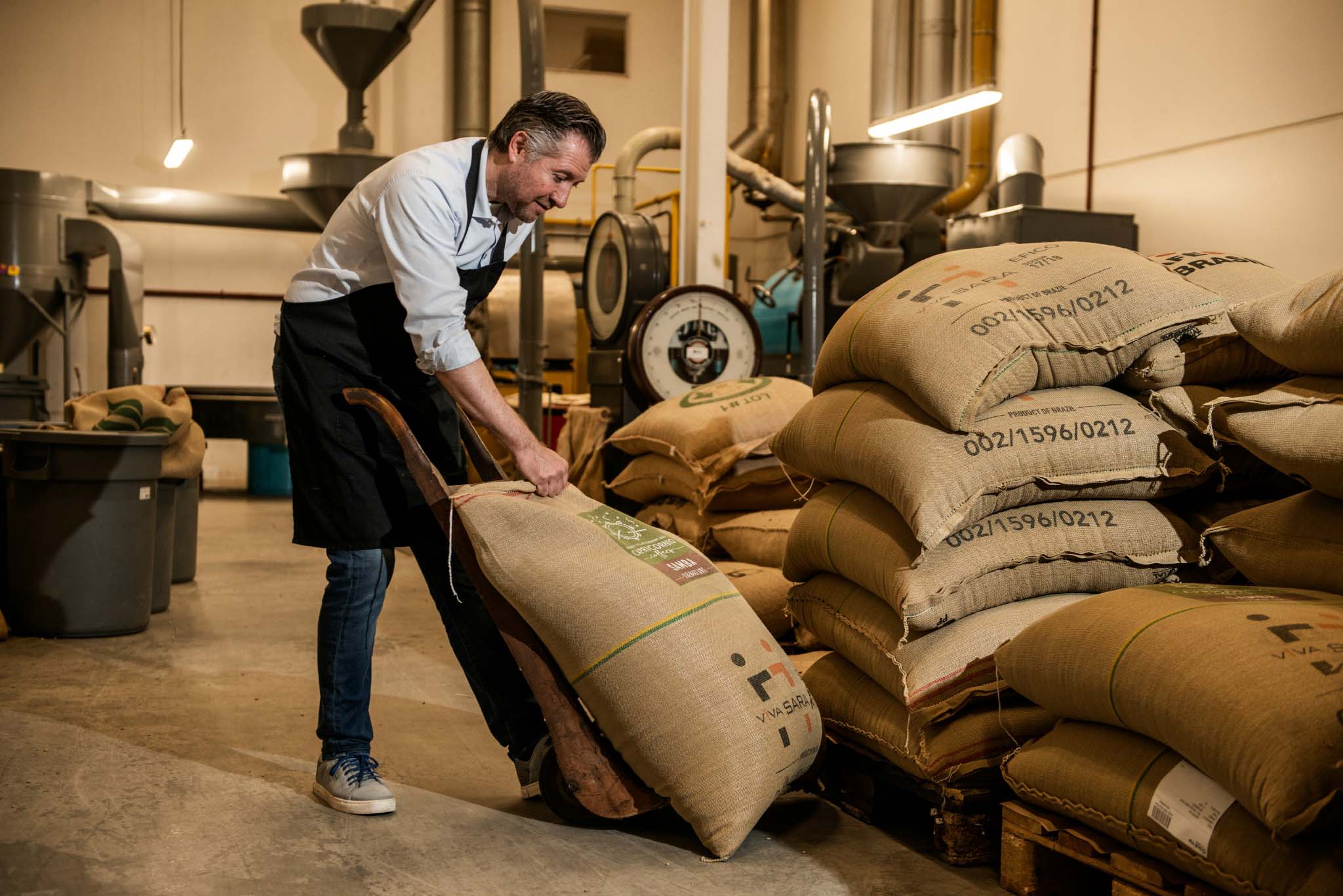 Koffiebrander Peter Deprez versleept juten zakken met koffies van verschillende origine. Collectie Viva Sara Koffie, Vichte. 